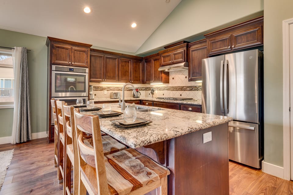 - Gourmet kitchen with breakfast bar  
- Granite island with stylish wood seating  
- Modern vacation rental cooking space