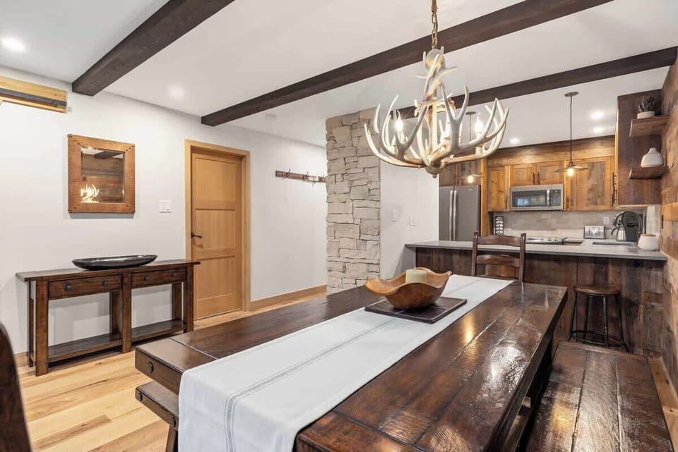 - Open dining and kitchen flow with rustic mountain charm  
- Stone pillar and wood finishes add natural texture  
- Ideal setting for shared meals and conversation  