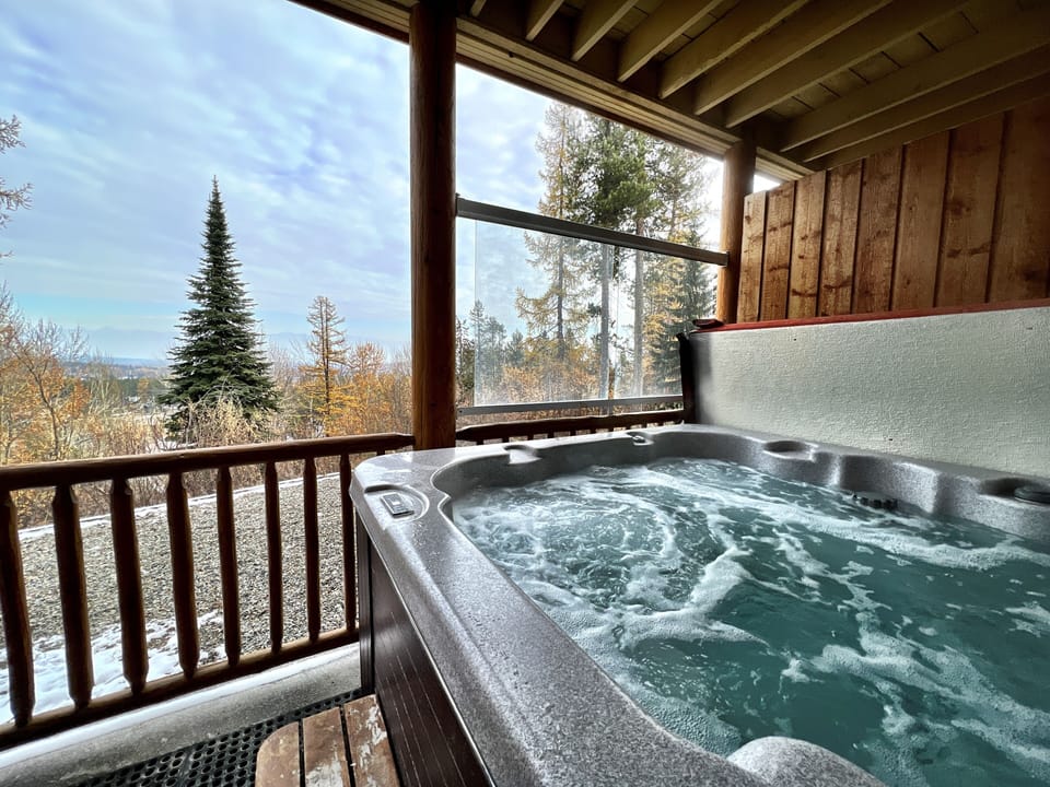 Hot tub on the deck with a stunning view of the Rocky Mountains and sunrise! Perfect for a soak after a hard day on the ski hill