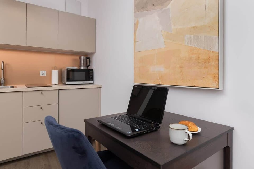 A kitchen corner with a work desk and a beige cabinetry setup blending into the space.

