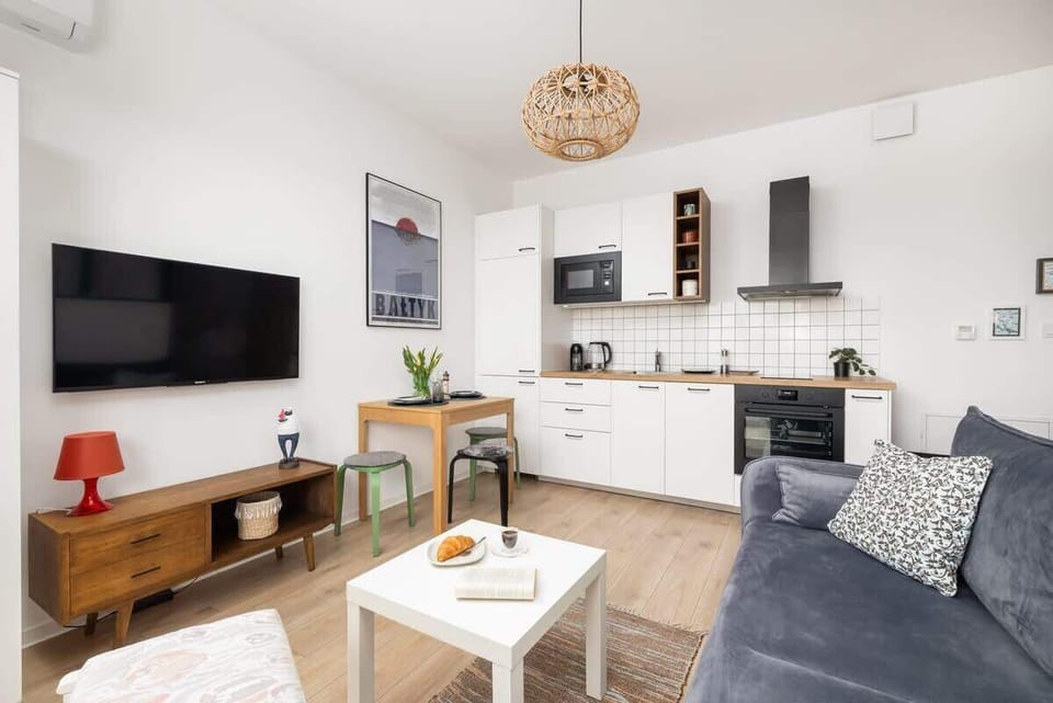 A side view of the living space, showing the kitchen and seating arrangement in a well-lit setting.

