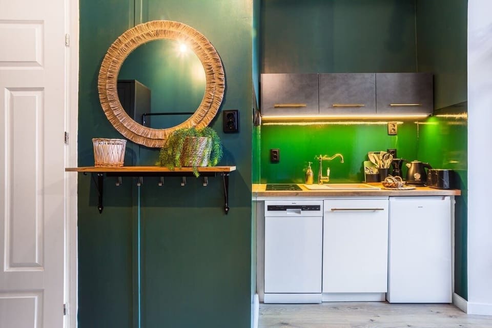 A small bar counter with a gold-framed mirror and plants, complementing the kitchenette.

