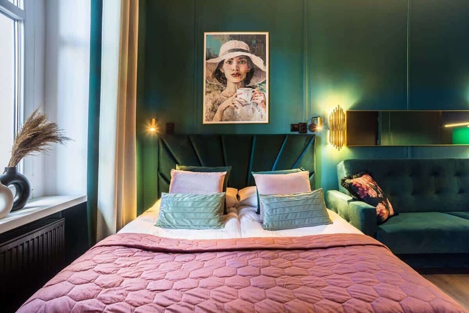 Another angle of the bedroom, showcasing a tufted headboard, pillows, and warm lighting.

