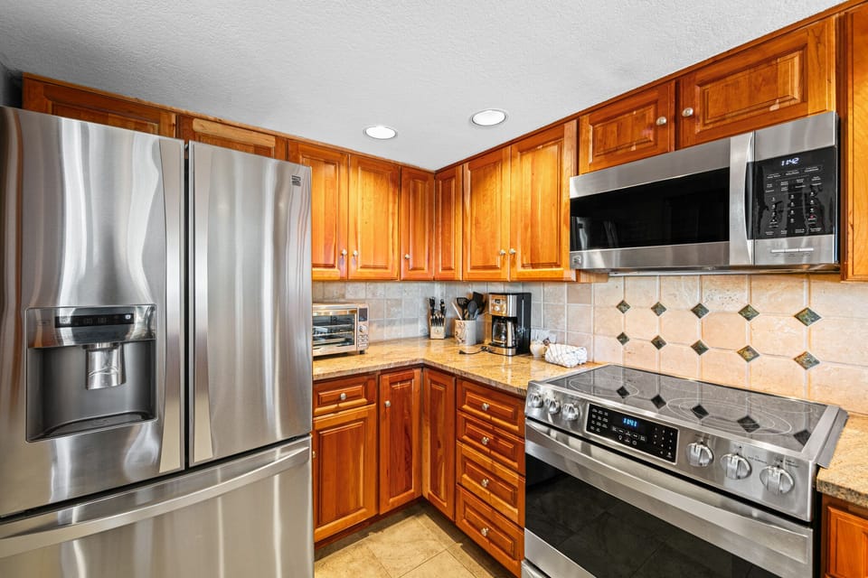 Your fully equipped kitchen features rich wood cabinets, granite counters, and stainless appliances for home-cooked meals.