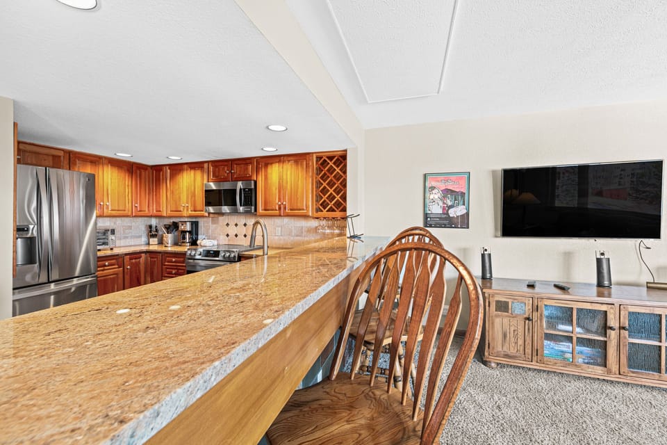 Your spacious kitchen features granite counters, rich wood cabinets, and stainless appliances—perfect for preparing meals while staying connected to the cozy living area.