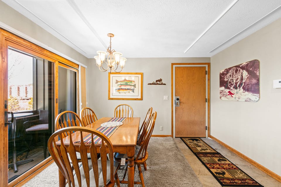 Gather around this welcoming dining table where warm wood tones and soft lighting create the perfect atmosphere for your memorable meals together.