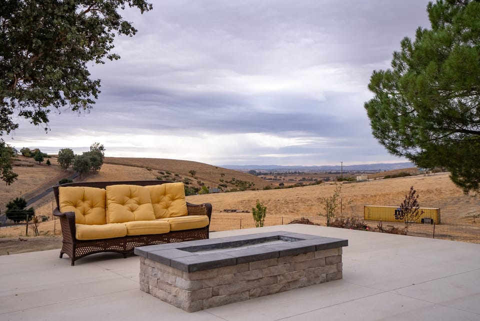 Gather around the fire pit beside sweeping hillside views