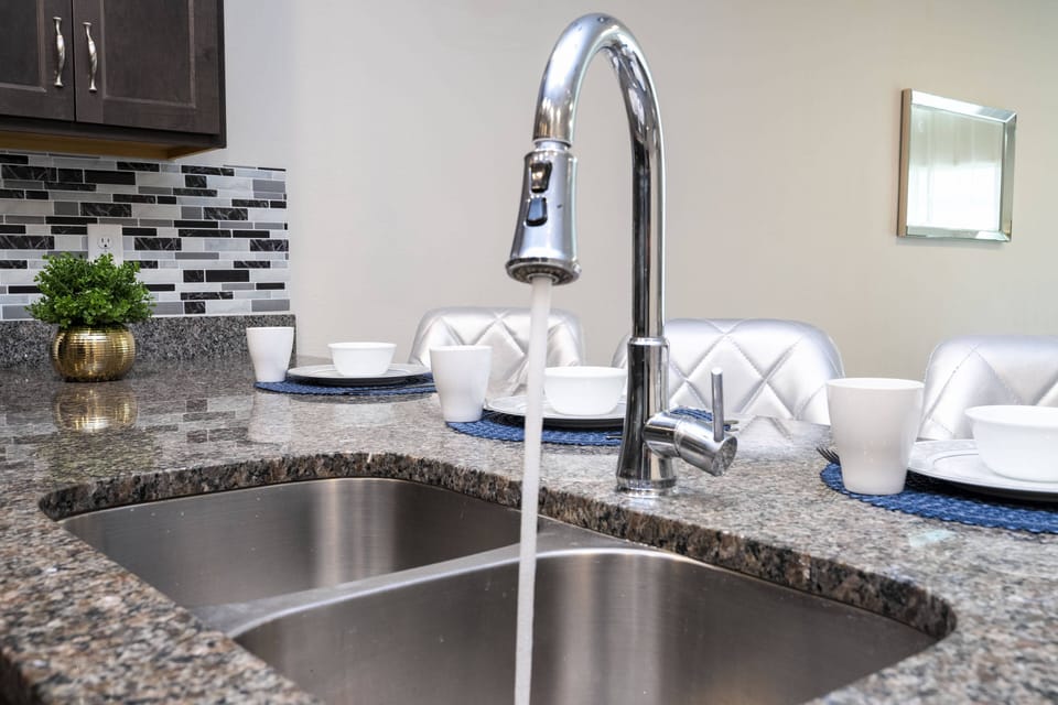 Cook in this stylish kitchen featuring sleek stainless steel fixtures and a beautiful granite countertop. The charming mosaic tile backsplash adds character, while the inviting dining area is ideal for shared meals and laughter.