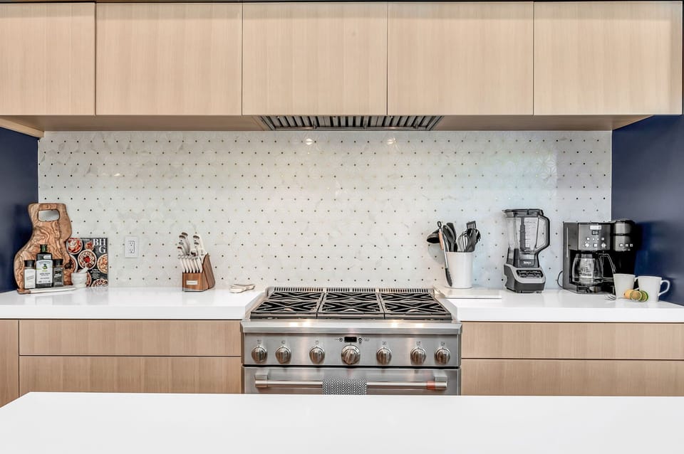 This professionally designed chef's dream kitchen is equipped with high-end GE Cafe stainless steel appliances, custom built cabinetry and a 10’ island