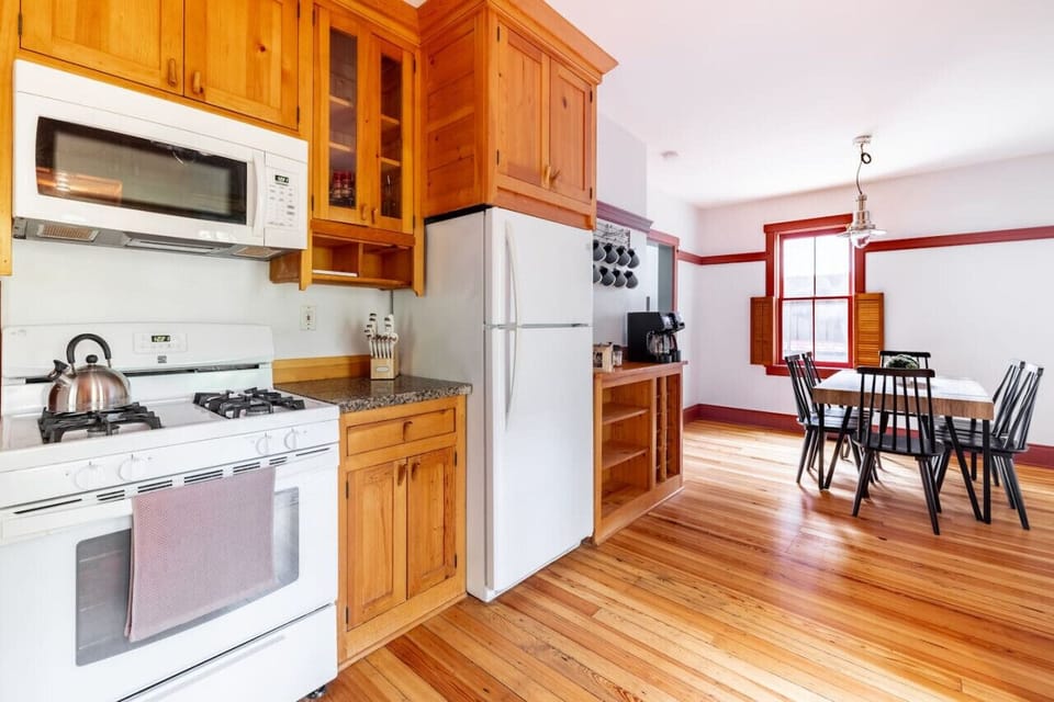 Fully equipped kitchen with modern appliances, flowing seamlessly into the dining area