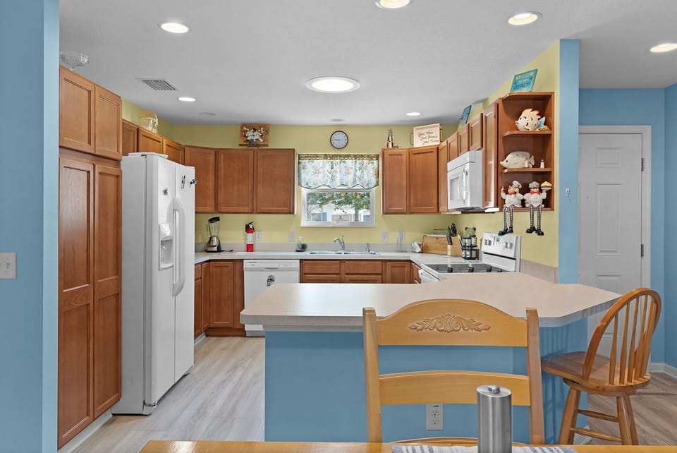 Picture yourself here in your fully equipped kitchen with warm wood cabinetry, ample counter space, and everything you need to prepare meals together during your stay.