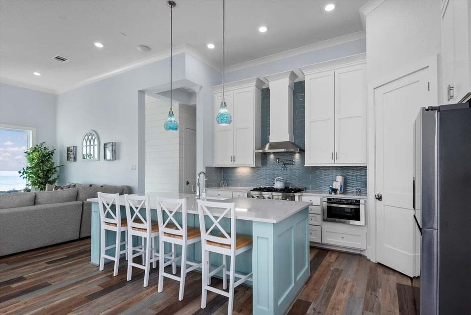 Open kitchen design featuring bar seating, custom cabinetry, stainless appliances, and plenty of space for entertaining guests.