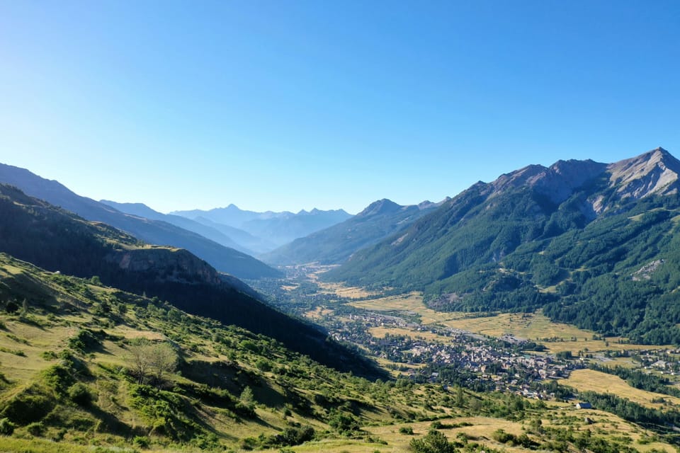 Sweeping alpine valley view with mountains under a clear sky