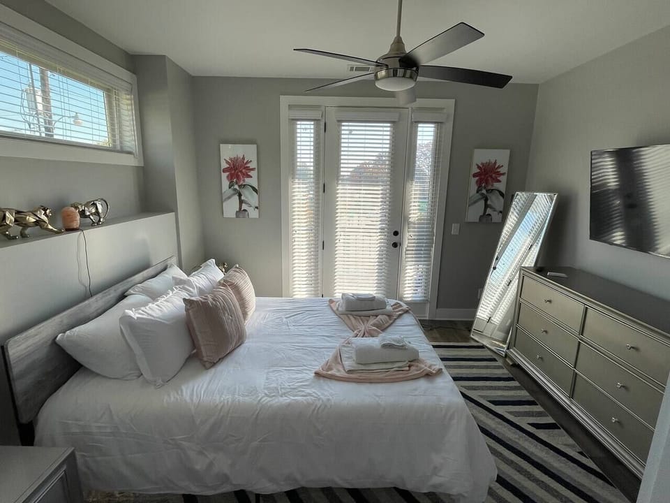 Bedroom Retreat: Bright and airy room with plush bedding, stylish decor, and access to a private patio!