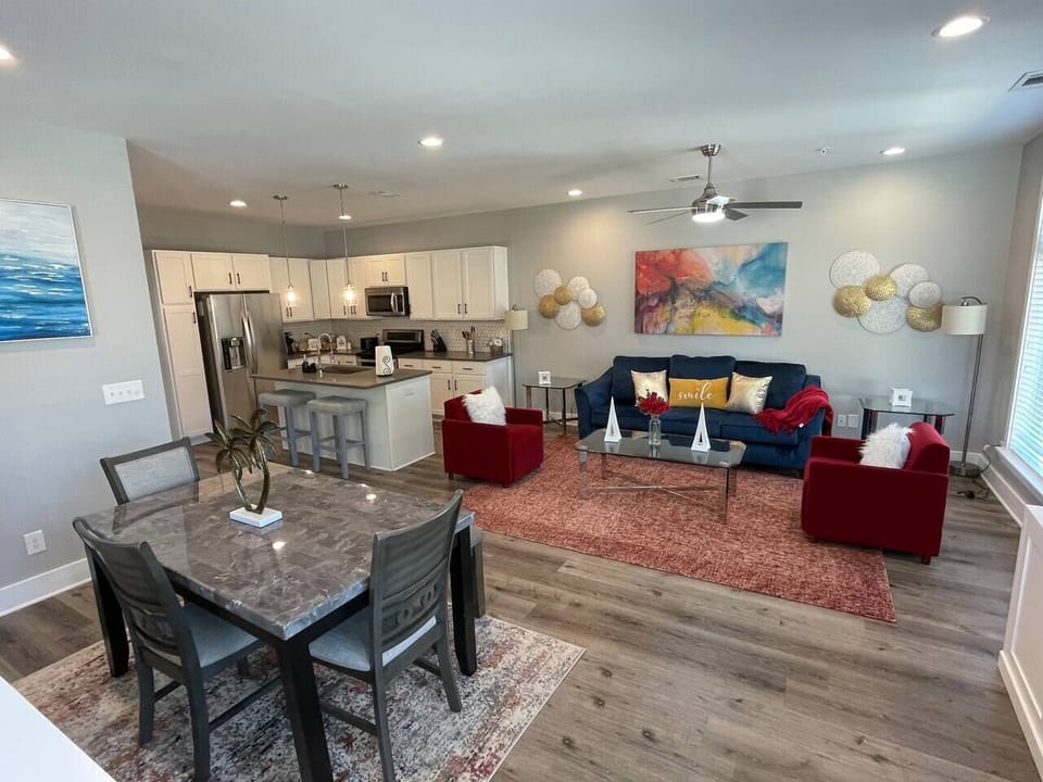 Living Area: Bright and airy space featuring vibrant accents, modern kitchen, and elegant dining for four!
