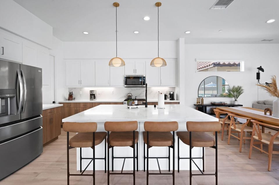 Sleek kitchen w/ large island seating, perfect for cooking & gathering together