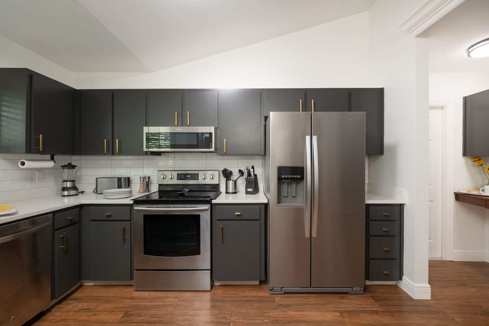 Experience a crisp, clean aesthetic in this thoughtfully updated kitchen featuring white quartz countertops and a classic subway tile backsplash. With ample storage and a seamless flow into the coffee nook.