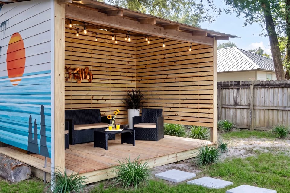 Your Private Backyard Oasis & Artistic Lounge Step outside to your own custom-built retreat, featuring a stunning hand-painted mural and modern slatted wood walls for ultimate privacy.