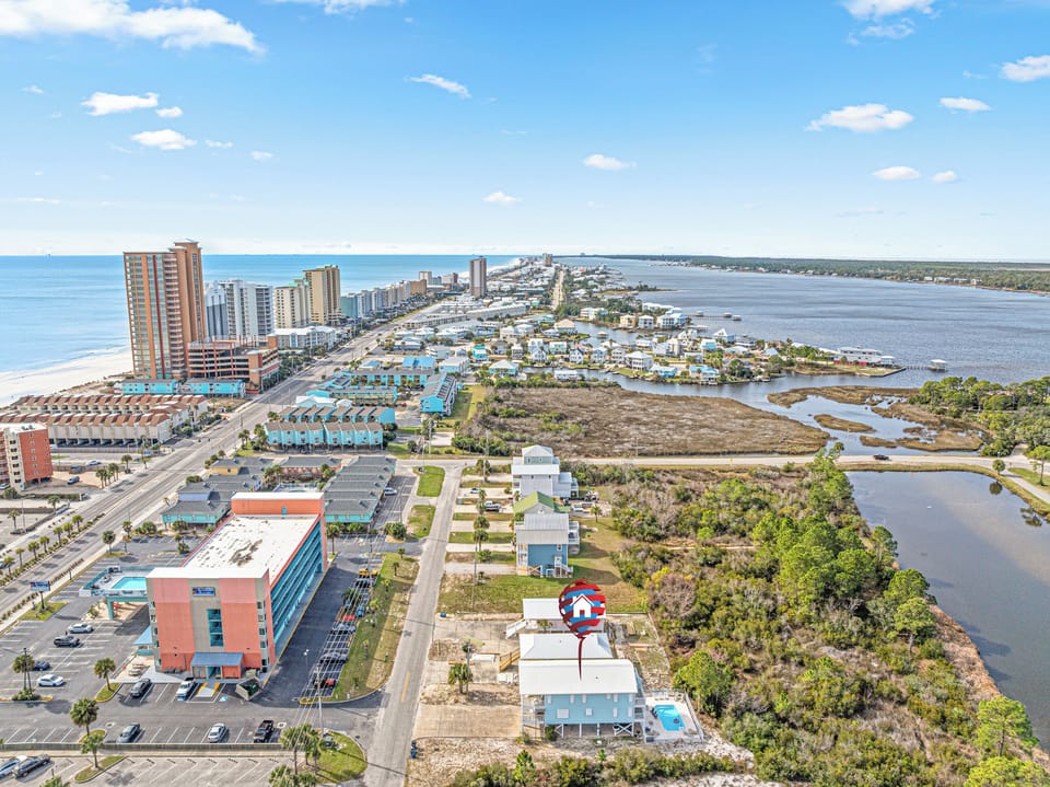 Elevated aerial view highlighting the home’s prime location between the Gulf beaches and the bay, offering easy access to both sunrise and sunset views.