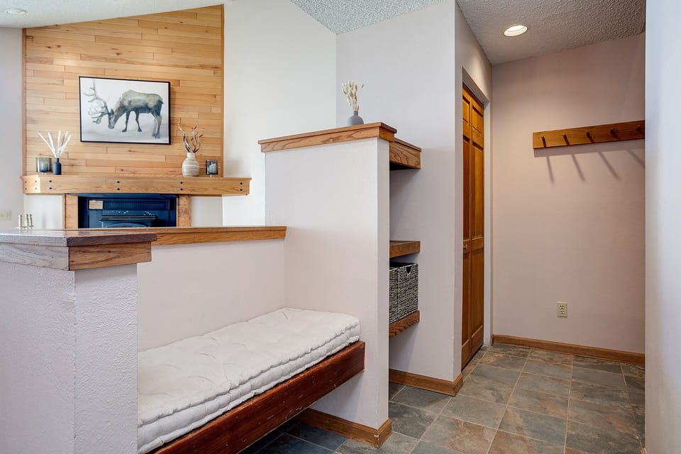 Settle into your cozy entryway with built-in bench seating and rustic fireplace warmth.