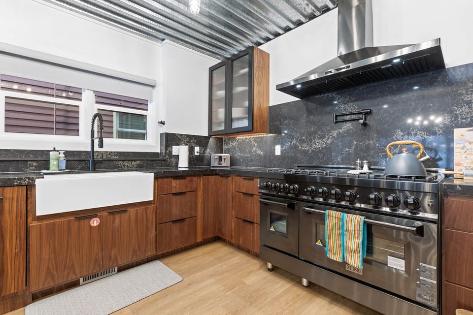 Kitchen: Sleek gas range, countertops, and deep sink.