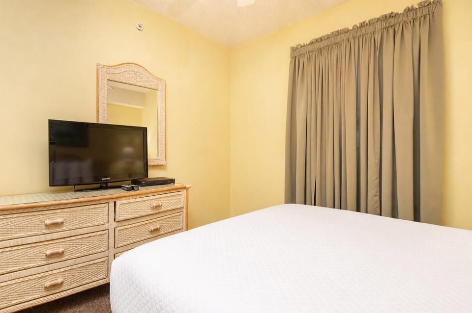 Unwind in this inviting guest bedroom featuring a TV, decorative dresser, and a cozy queen bed