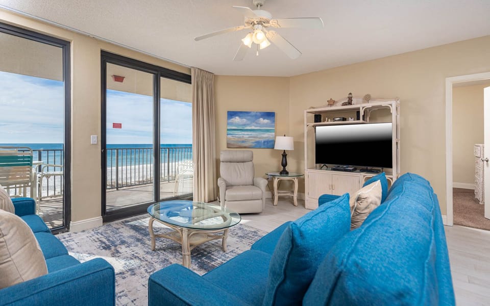 Relax in the inviting living area featuring a sofa with queen sleeper, flat-screen TV, and stunning beach views