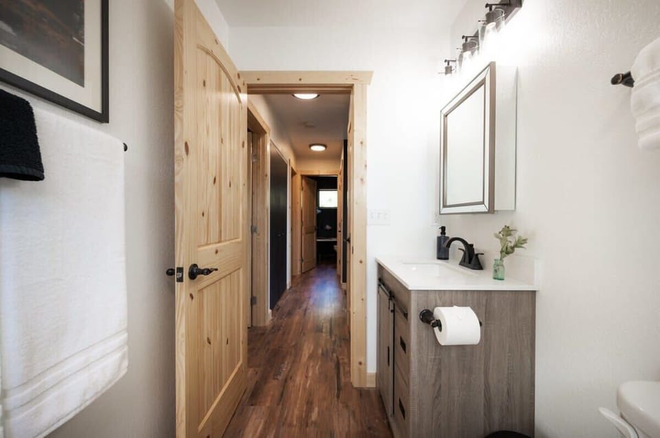 Step into luxury and indulge in one of the bathrooms of this cozy cabin. Prepare to be captivated by the full-sized glass shower, adorned with a lavish rainfall showerhead and a convenient handheld showerhead for an invigorating experience.