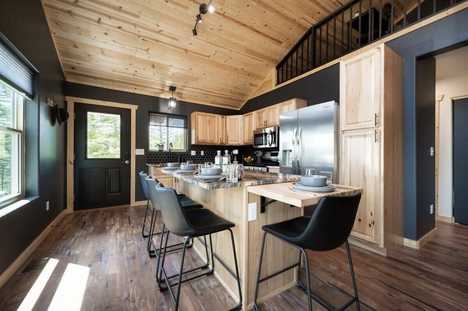 The dining area features a polished natural granite center island with seating for four via a butcher block extension for extra table space. Indulge your inner chef in the well-stocked kitchen with herbs, utensils, and prep/serving bowls and dishes.