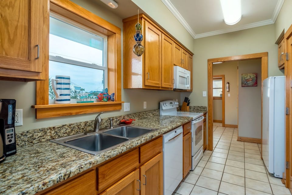 Cook your favorite meals in this fully equipped kitchen with granite countertops, wood cabinets, and all the appliances you need for a comfortable stay.