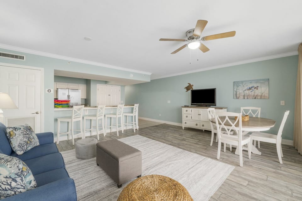 Kitchen area with 4 bar stools and seating for 4 at the dining table