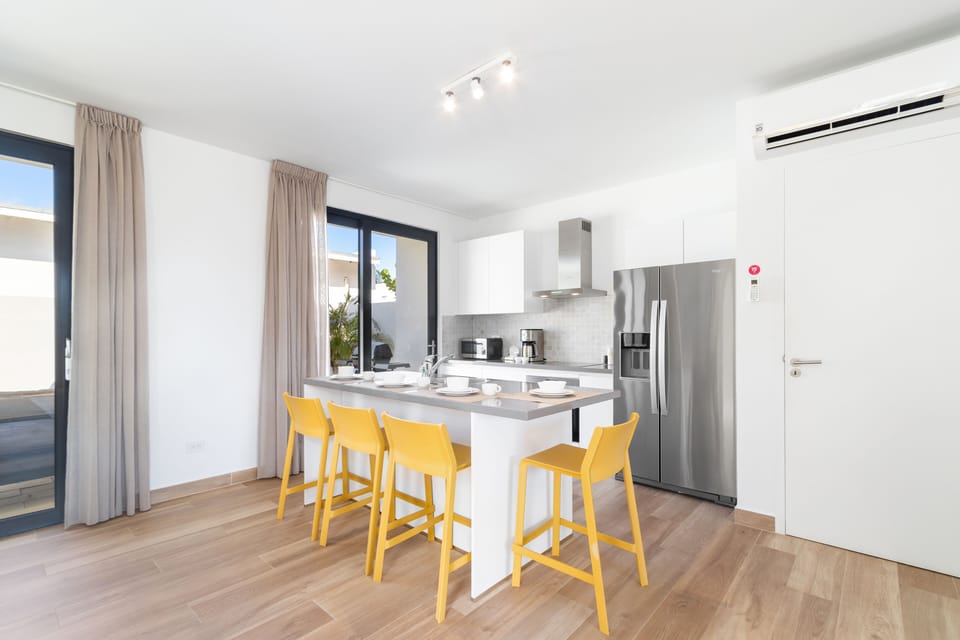 Well-Designed Kitchen of the 3BR Townhouse in Noord Aruba - Integrated appliances for a seamless and stylish appearance - Thoughtful placement of kitchen essentials for easy access - Open Concept Kitchen connecting to dining Area