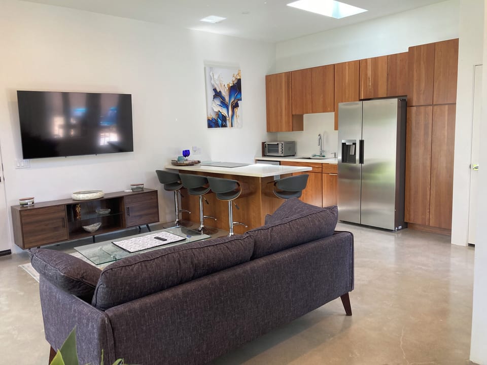 Living and kitchen with custom cabinates and stainless steel appliances.