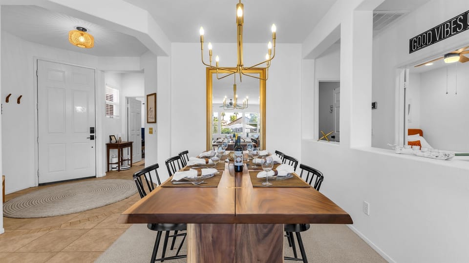 Stylish dining room with a modern chandelier and a golden mirror adding warmth and elegance