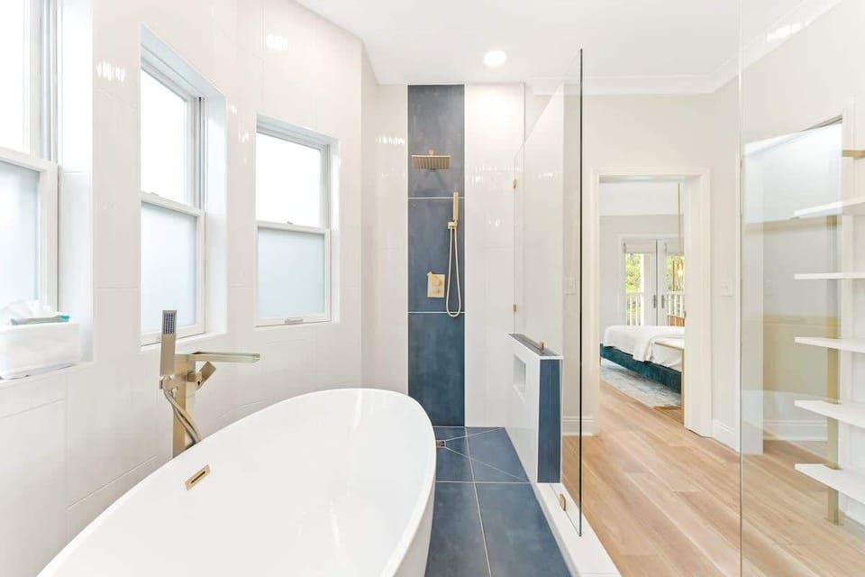 Luxurious primary bathroom with double rainfall showerheads and soaker tub.