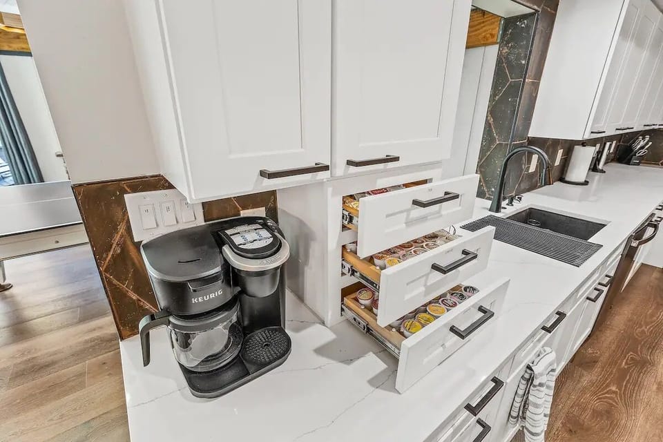 Coffee pot and single cup Keurig machine in kitchen. We have some coffee to start you out with as well as sugars and other goodies.