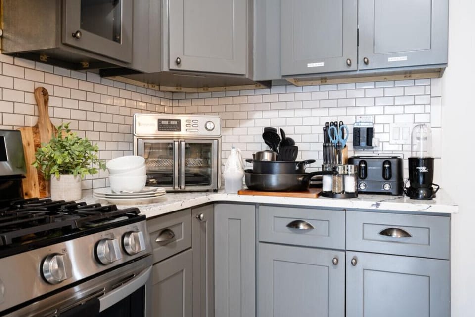 Elevate your culinary creations with our fully stocked kitchen, boasting an air fryer, double toaster, magic bullet, waffle maker, various pots, mixer, sharp knives, cutting boards, and a complete dining set.