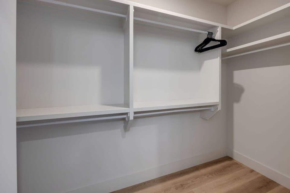 Primary Bathroom (Primary Bedroom en-suite) with dual vanity sinks, large walk-in closet, and stand-in shower.