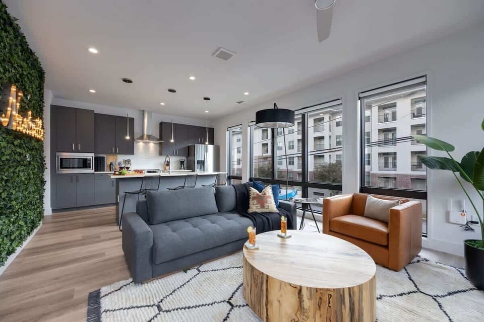 Bright open living space featuring a smart flat-screen TV, designer furnishings, and access to the private patio.