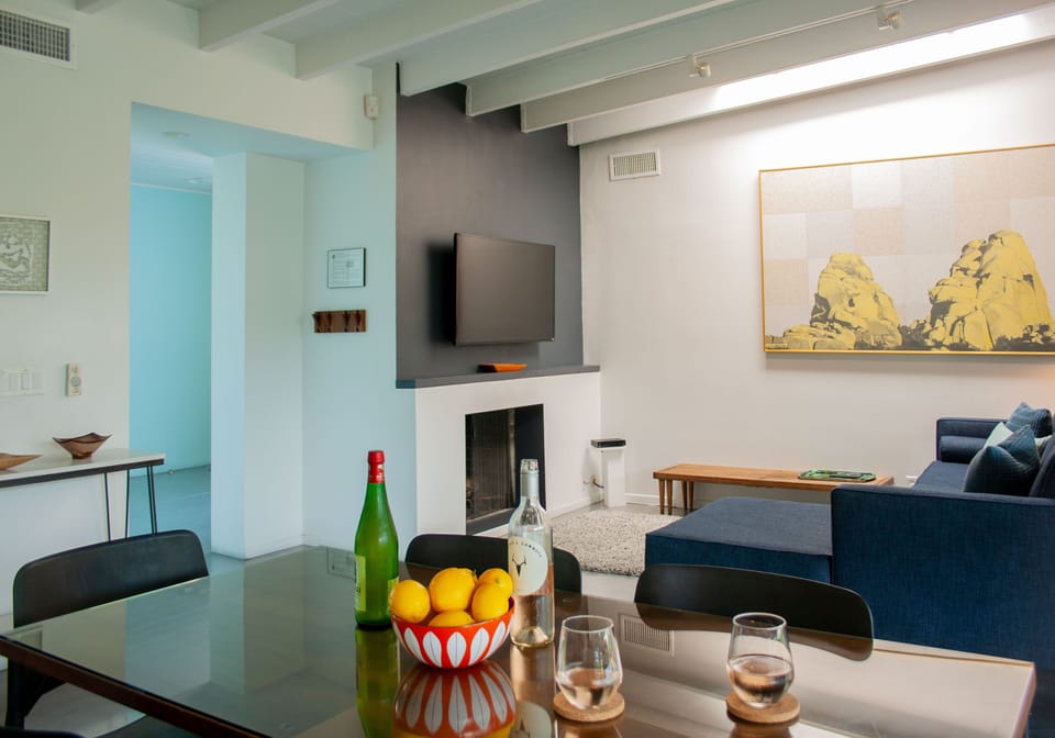 Dining area opens to living room with fireplace, TV, and modern furnishings
