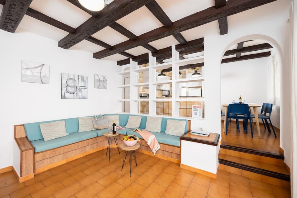 Open-plan living room with sofa, dining area, kitchen, ornamental fireplace, WiFi internet, and satellite TV