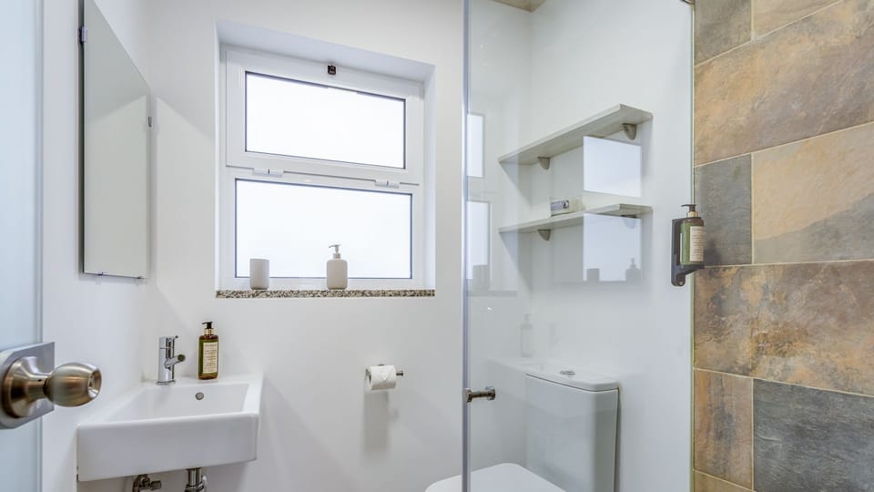 Rejuvenate in this sleek, bright bathroom, featuring a refreshing walk-in shower and contemporary fixtures for ultimate comfort.
#ModernBathroom #WalkInShower #LovelyStay