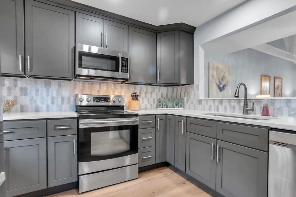 You'll love preparing meals in this sleek modern kitchen with stainless steel appliances, stylish gray cabinetry, and beautiful geometric backsplash.