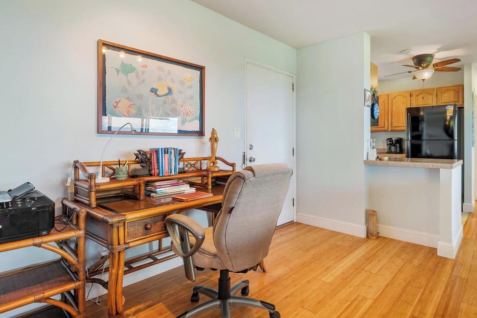 Stay productive in your dedicated workspace with bamboo desk, comfy chair, and inspiring artwork while the kitchen awaits nearby.