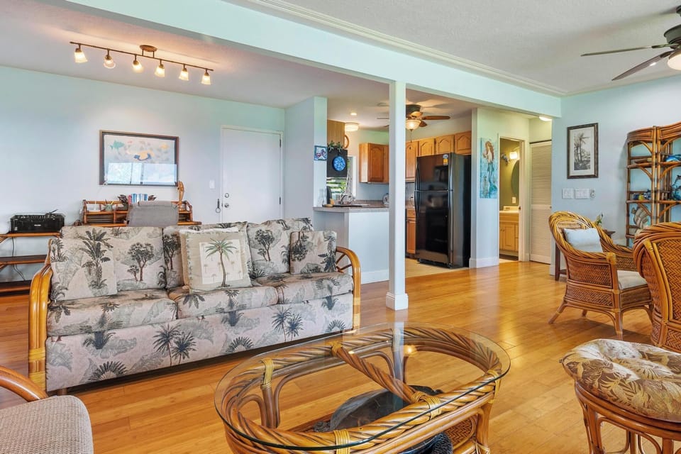 Relax in your tropical-themed living room with bamboo furniture and palm-print accents, while enjoying the open flow to your fully equipped kitchen.