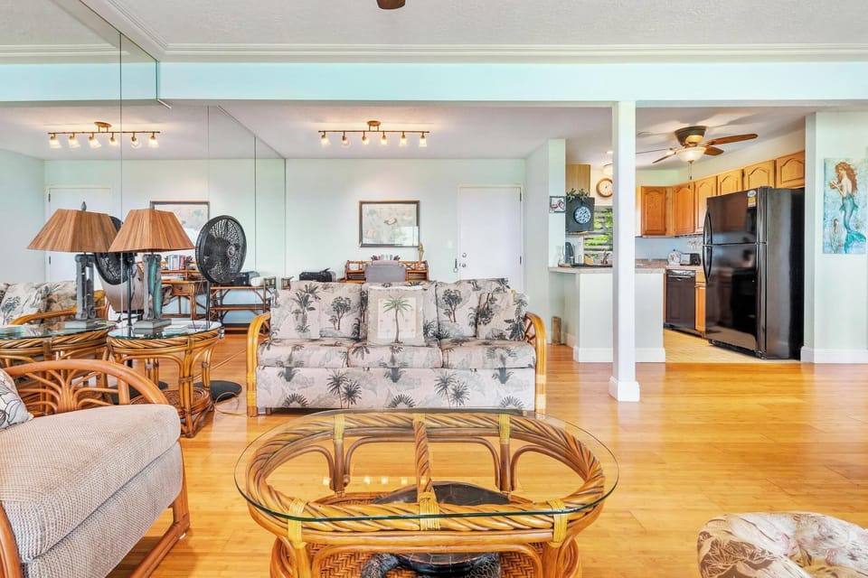 Relax in your tropical-themed living space with gleaming hardwood floors, coastal decor, and an open kitchen perfect for vacation meals.
