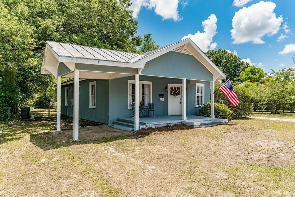 Front of the home shows parking and large covered front porch