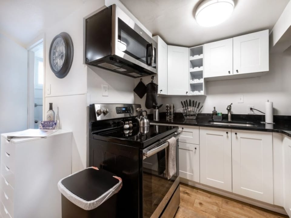 stove/oven, microwave, garbage can, paper towels, sink