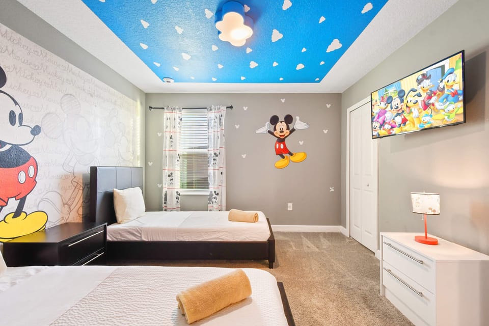 Charming Mickey-themed bedroom with twin beds and fun decor!
