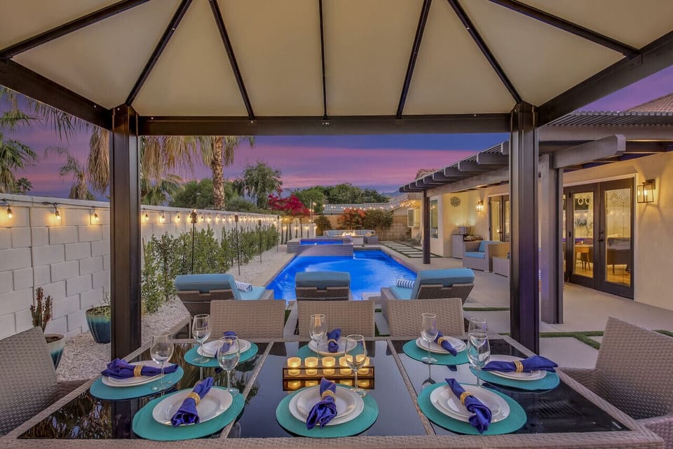 Covered patio lounge overlooking the lit pool, made for twilight gatherings